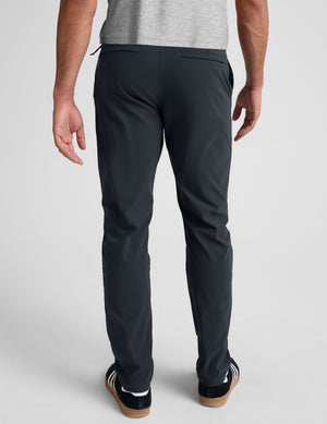 man wearing a gray t-shirt and navy chino pants with pockets against a plain background. 