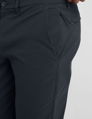 man wearing a gray t-shirt and navy chino pants with pockets against a plain background. 