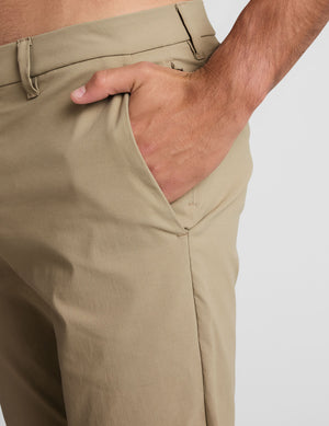 man wearing beige chino pants with side pockets on a plain background.