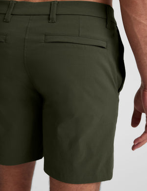 green chino shorts with pockets on a plain background. 