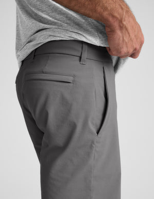 Gray shorts worn by a person on a light gray background. 