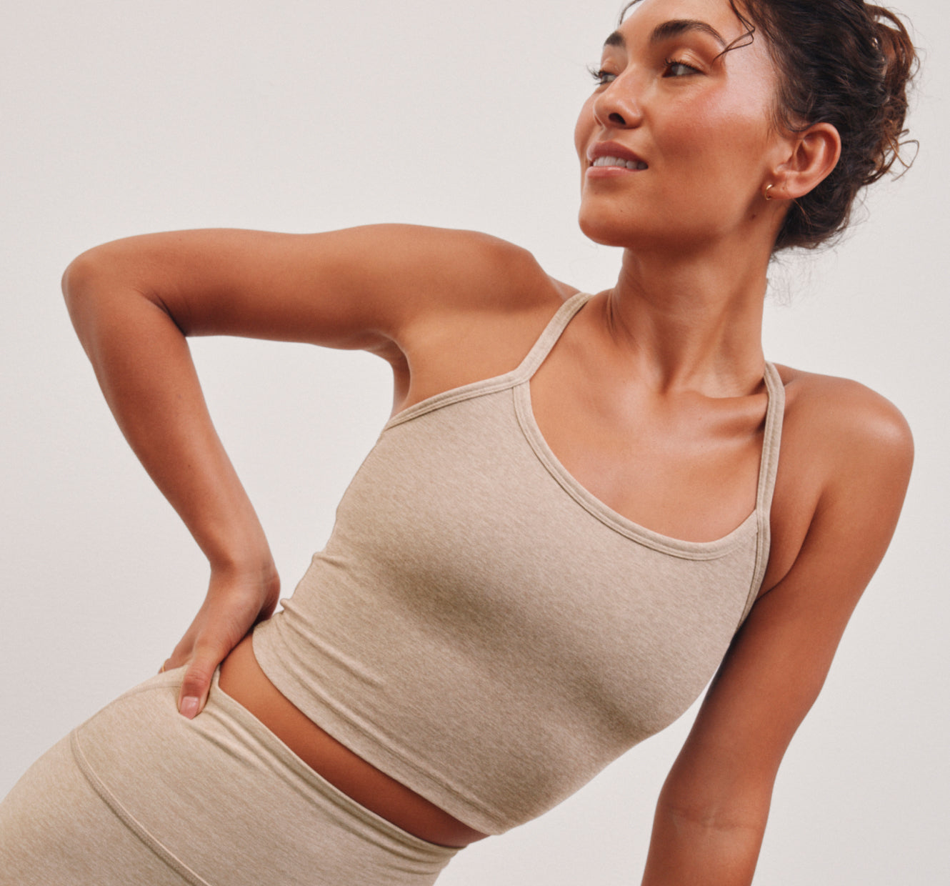 model is wearing a beige slim racerback cropped tank top. 