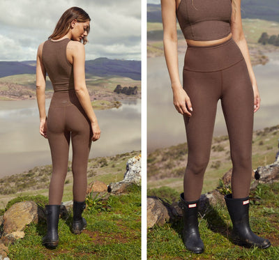 model is wearing brown high-waisted midi leggings. 