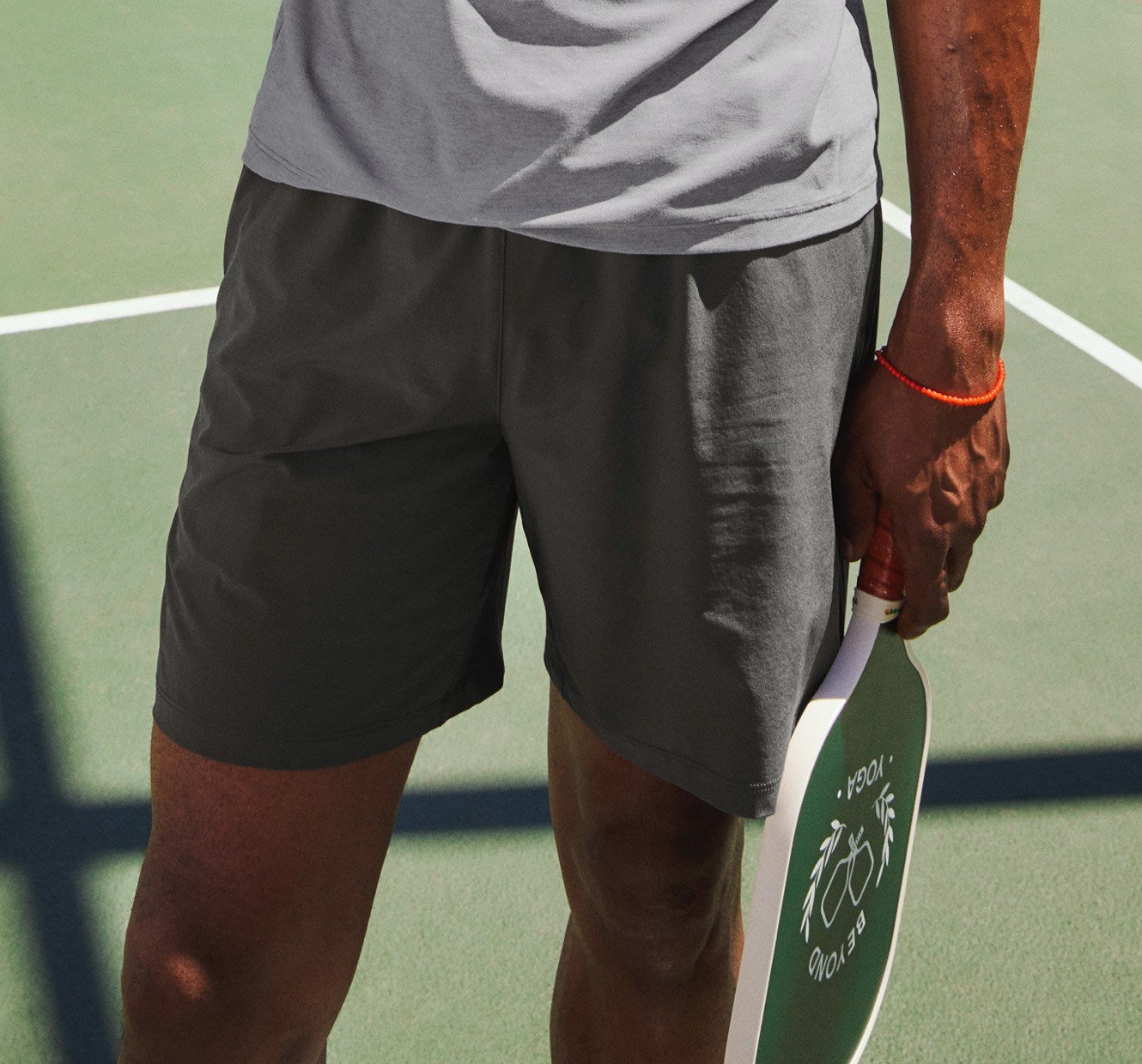 model is wearing a gray men's t-shirt and charcoal gray men's shorts. 