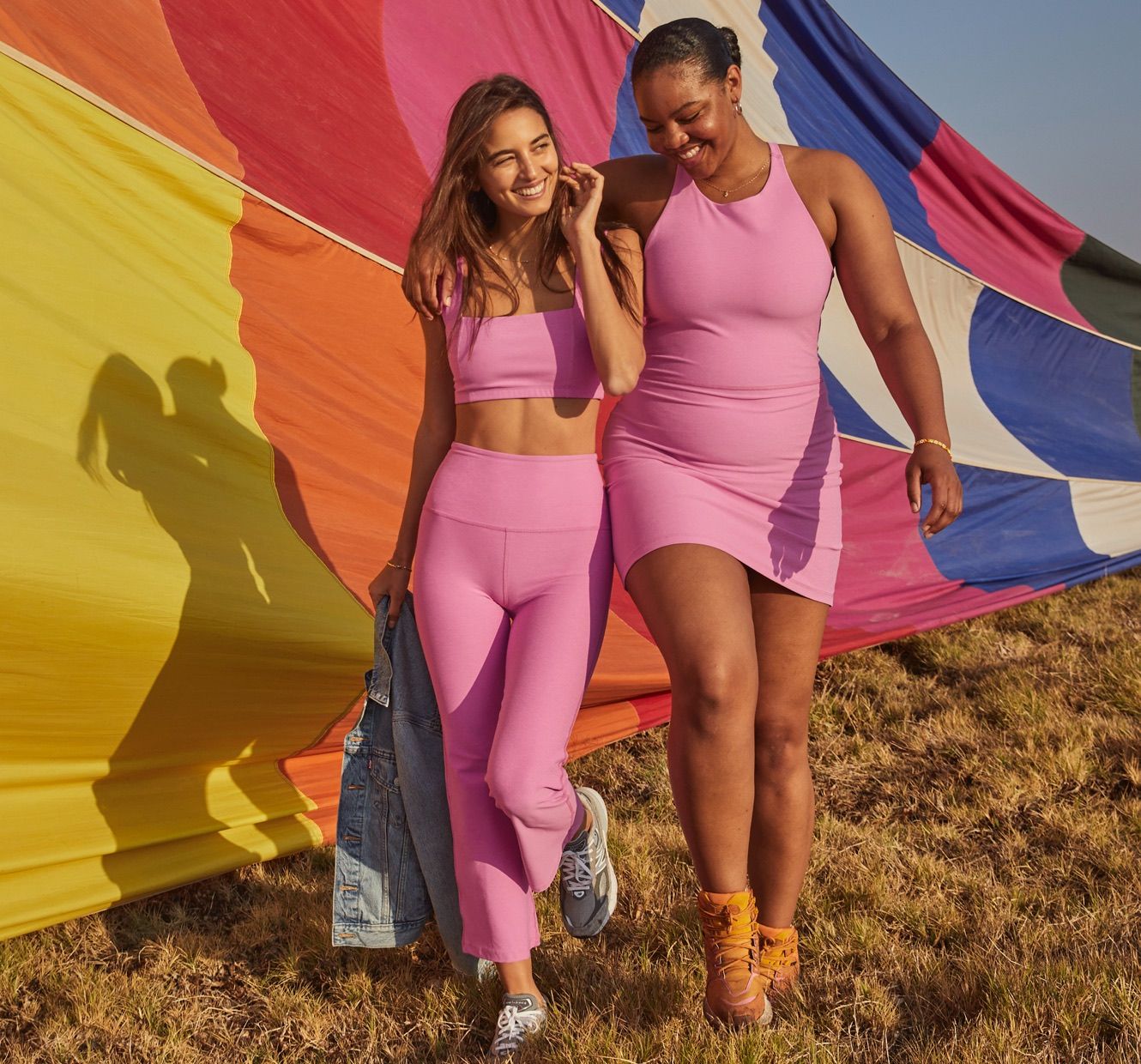 model on the left is wearing a pink square neck bra top and pink hig-waisted flare capri pants. model on the right is wearing a pink high-neck mini dress. 