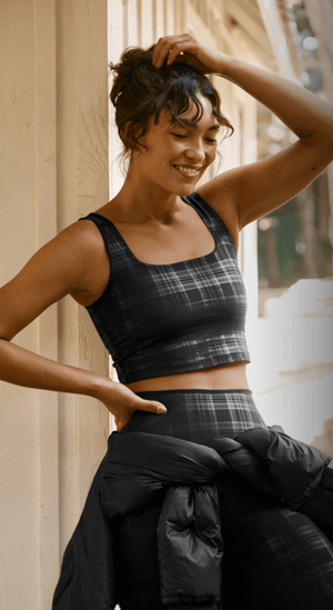 Woman in plaid cropped tank and leggings outdoors. 
