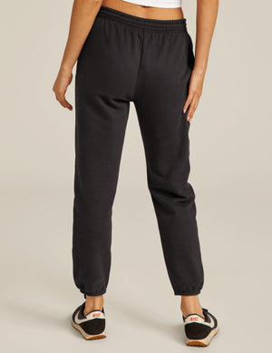 Rear view of the black On the Go Jogger featuring a relaxed fit, elastic waistband, and gathered ankle cuffs.