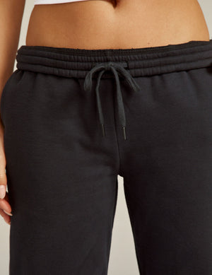 Close-up of black On the Go Jogger pants featuring a gathered elastic waistband and matching drawstring on a model.