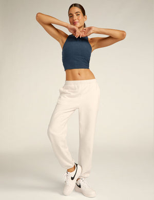 Smiling woman in cream On the Go Jogger and blue crop top. Relaxed fit with elastic waistband and gathered ankle cuffs.