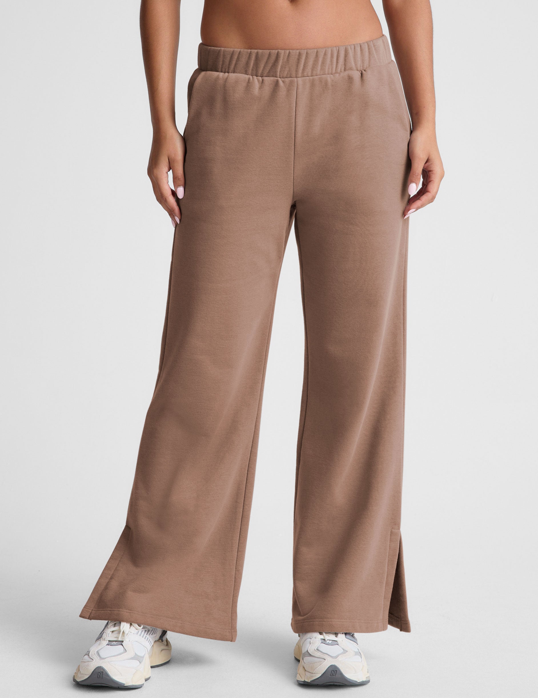 brown wide leg sweatpants with pockets and side slits by ankle. 