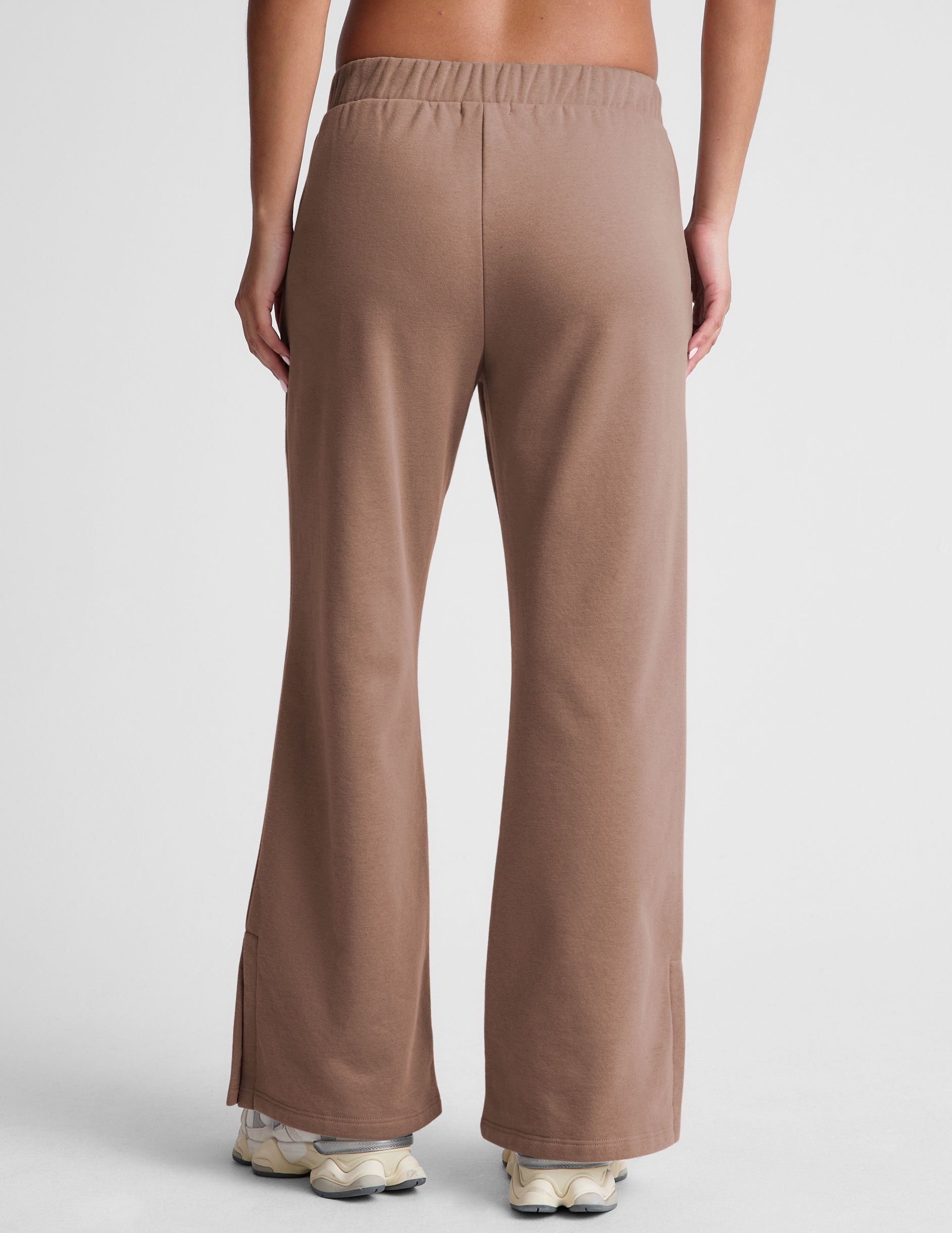 brown wide leg sweatpants with pockets and side slits by ankle. 