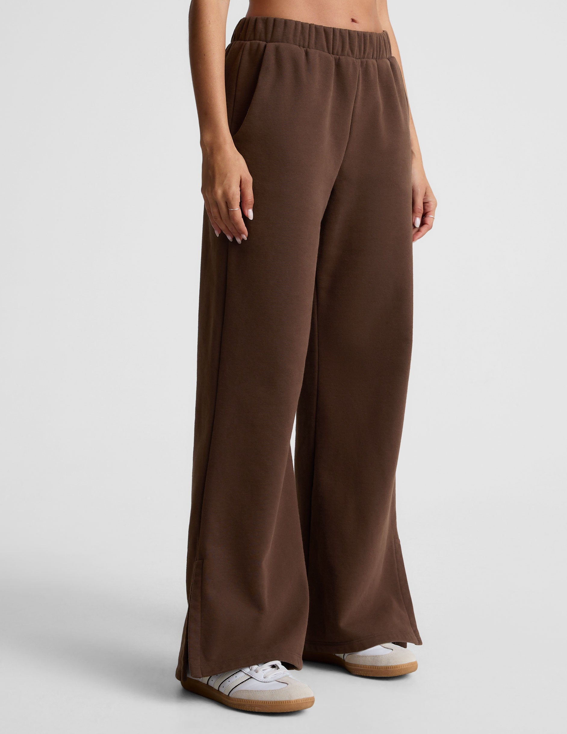 brown mid-rise, wide leg fleece sweatpants with side slits at the ankle and pockets. 