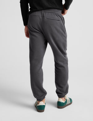 Person wearing gray sweatpants on a white background. 