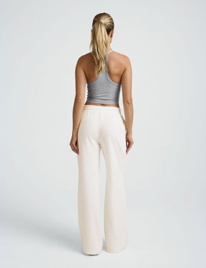 model wearing a grey tank and white fleece wide leg pants against a plain background. 
