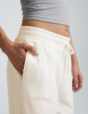 model wearing a grey tank and white fleece wide leg pants against a plain background. 