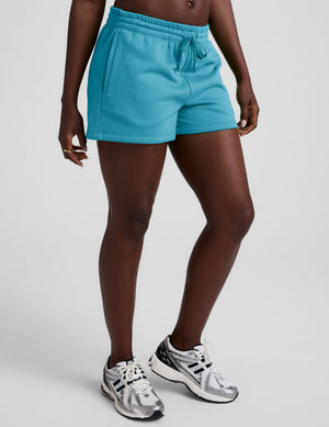 Person wearing bright blue shorts on a plain background. 