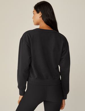 black loose-fitting classic length crew neck sweatshirt. 