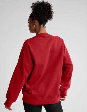 model wearing a red oversized crewneck fleece sweatshirt on a plain background. 