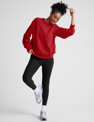 model wearing a red oversized crewneck fleece sweatshirt on a plain background. 