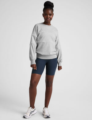 gray fleece crewneck sweater with white contrast piping trim at chest and sleeves. 