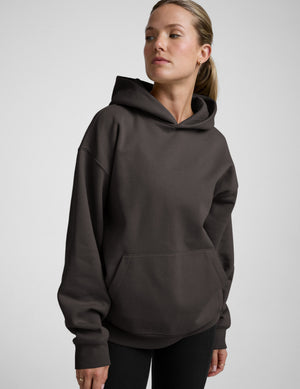 Woman wearing a dark gray hoodie on a light gray background | womens