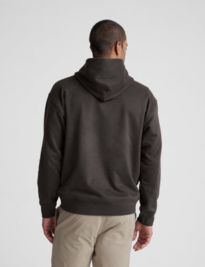 Man wearing a dark brown hoodie on a light gray background