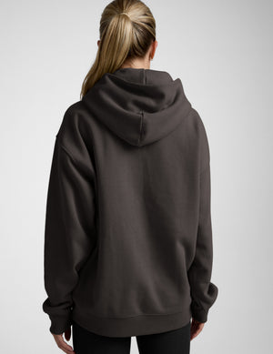 Person wearing a dark gray hoodie on a light gray background | womens