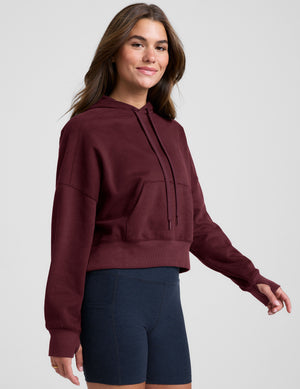 red cropped pullover with a hood with drawcord and a kangaroo pocket. 