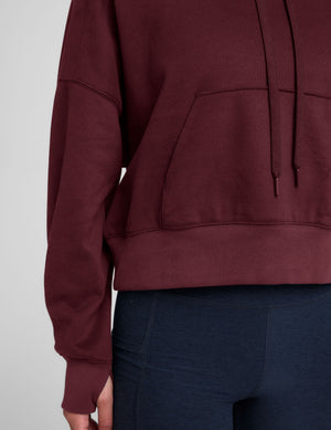 red cropped pullover with a hood with drawcord and a kangaroo pocket. 