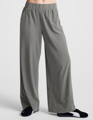 Gray Beyond Yoga Easy Wide Leg Pant with an elastic waistband and relaxed silhouette on a person wearing sneakers.