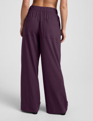 Purple wide-leg pants worn by a person on a plain background. 