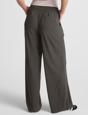 Back view of the dark gray Easy Wide Leg Pant featuring an elastic waistband, back pockets, and a relaxed, flowy fit.