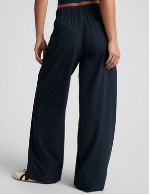 Rear view of navy Easy Wide Leg Pant showing the relaxed fit, elastic waist, and back pockets on a model.