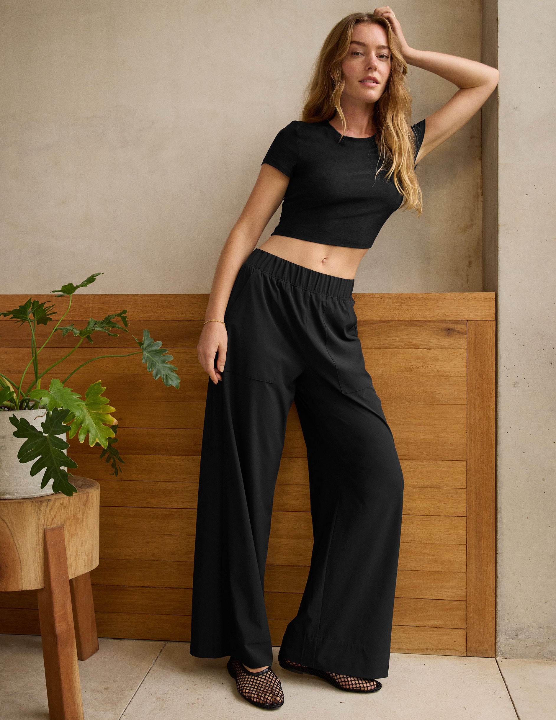 black mid rise relaxed fit wide leg pant with front side seam pockets and back pockets. 