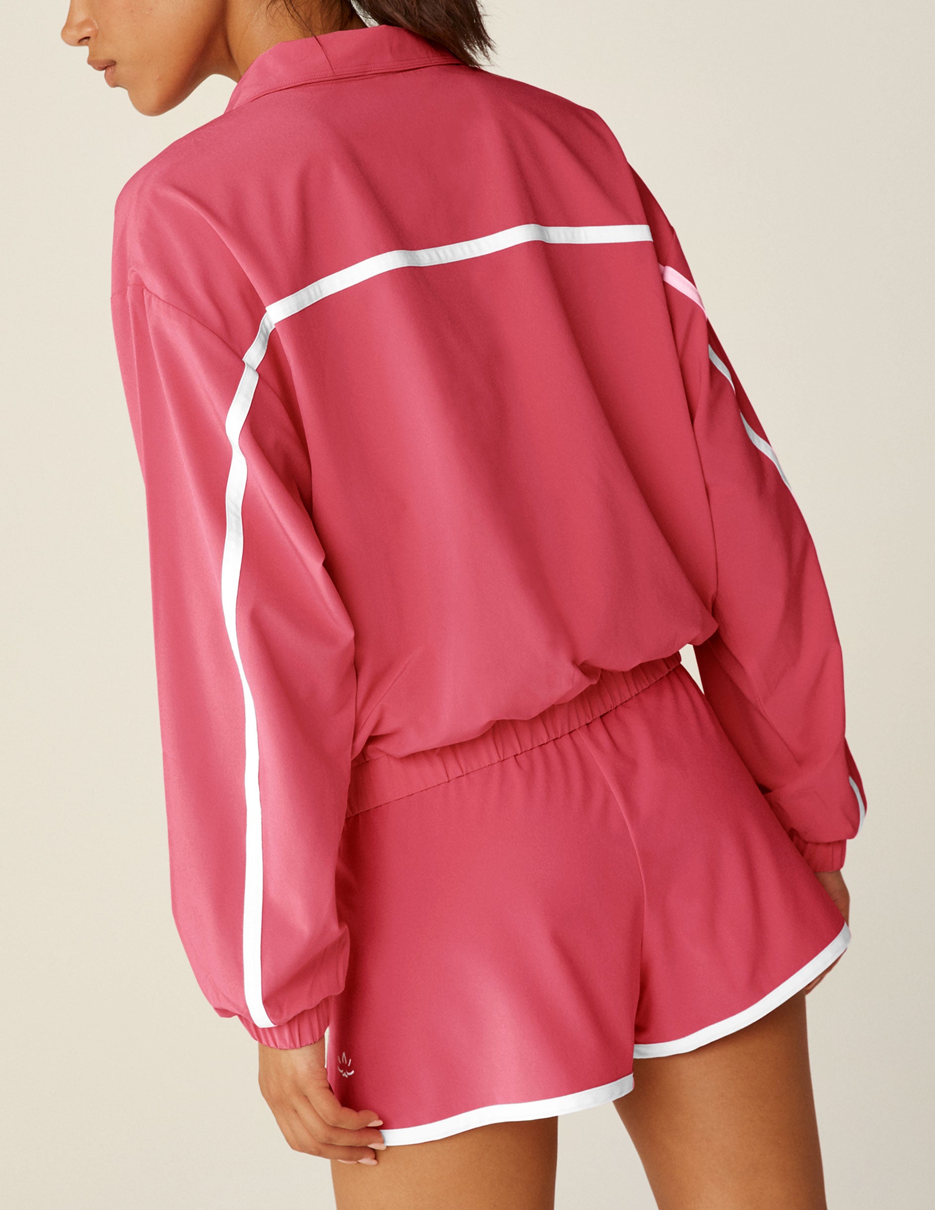 pink zip-up jacket with white trim and pockets. 