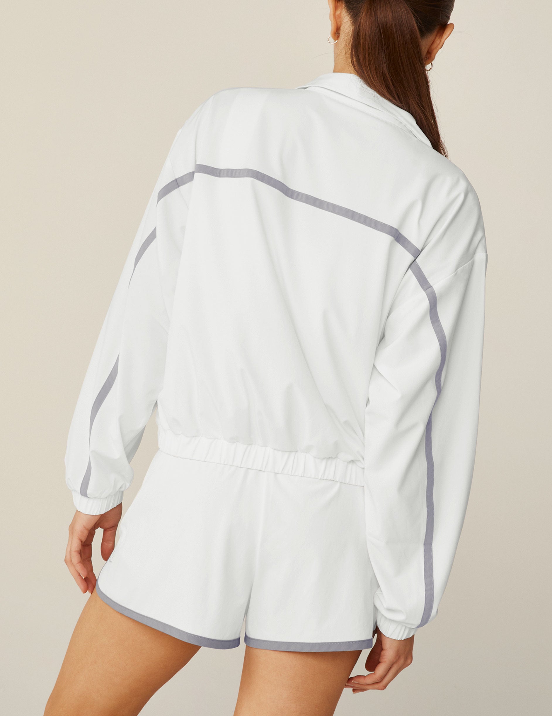 white zip-up jacket with grey lining. 