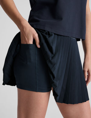 blue mini length pleated skirt with an exposed stripped elastic waistband​ and 
internal performance shorts with pockets​. 