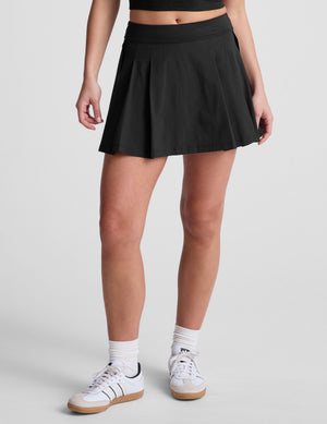 Front view of the black Score Pleated Skirt, featuring a mini A-line silhouette with structured front pleats.