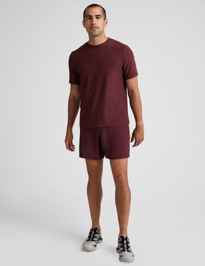 A man wears maroon Pivotal 2.0 Men's Lined Short 7