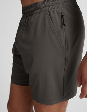 man wearing a gray t-shirt and graphite shorts on a white background.