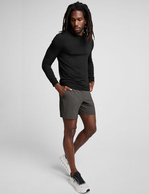 man wearing a long sleeve and graphite shorts on a white background. 