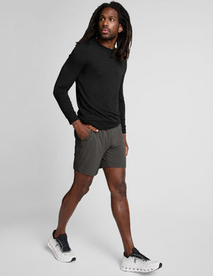 man wearing a long sleeve and graphite shorts on a white background. 