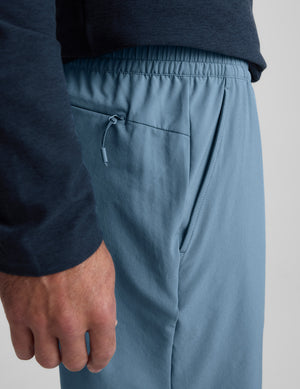 Blue shorts worn by a person on a light gray background. 