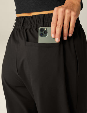 Back view of black Status Wide Leg Trousers featuring an elastic waistband with belt loops and a functional back welt pocket.