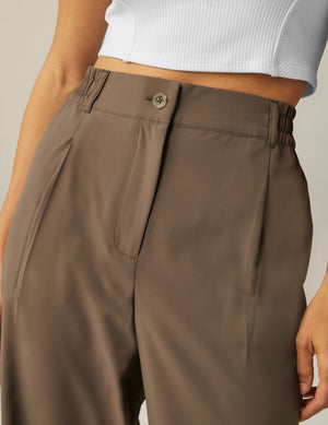 Close-up of Status Wide Leg Trousers in Dune brown, featuring a button fly, elasticated side waistband, and front pleats.