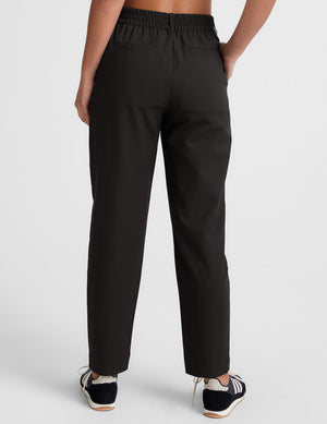 Back view of the black Status Tapered Pant with an elastic waistband, back welt pockets, and a cropped tapered leg.