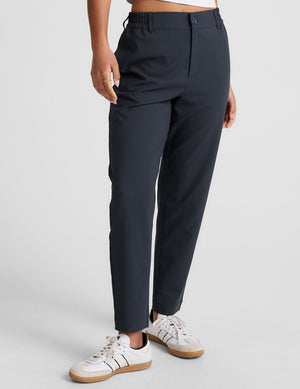 Black Status Tapered Pant featuring a mid-rise waistband with belt loops and a slim, tapered leg on a model.