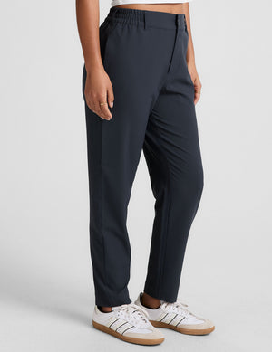 Black Status Tapered Pant on a model, featuring a mid-rise elasticated waistband, belt loops, and slim tapered legs.