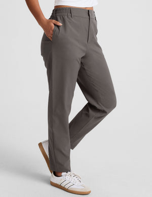 Status Tapered Pant in dark gray with a mid-rise waist, side pockets, and tapered leg, styled with white sneakers.