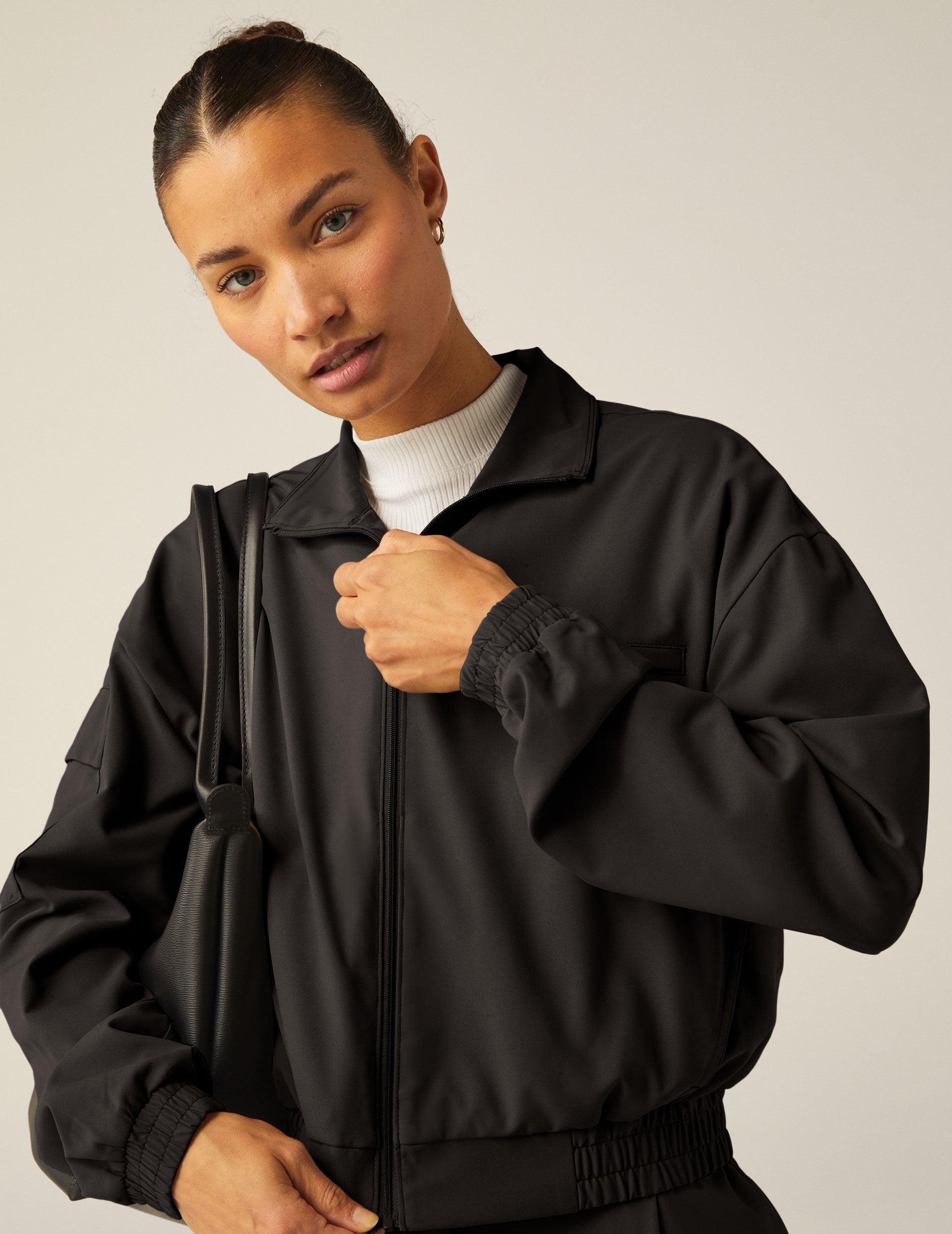 black zip-up jetstretch woven jacket with a collar. 